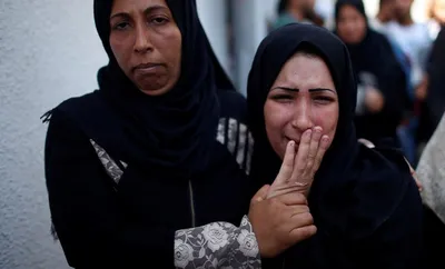 israeli forces kill two palestinians near border as gaza buries 60 bodies